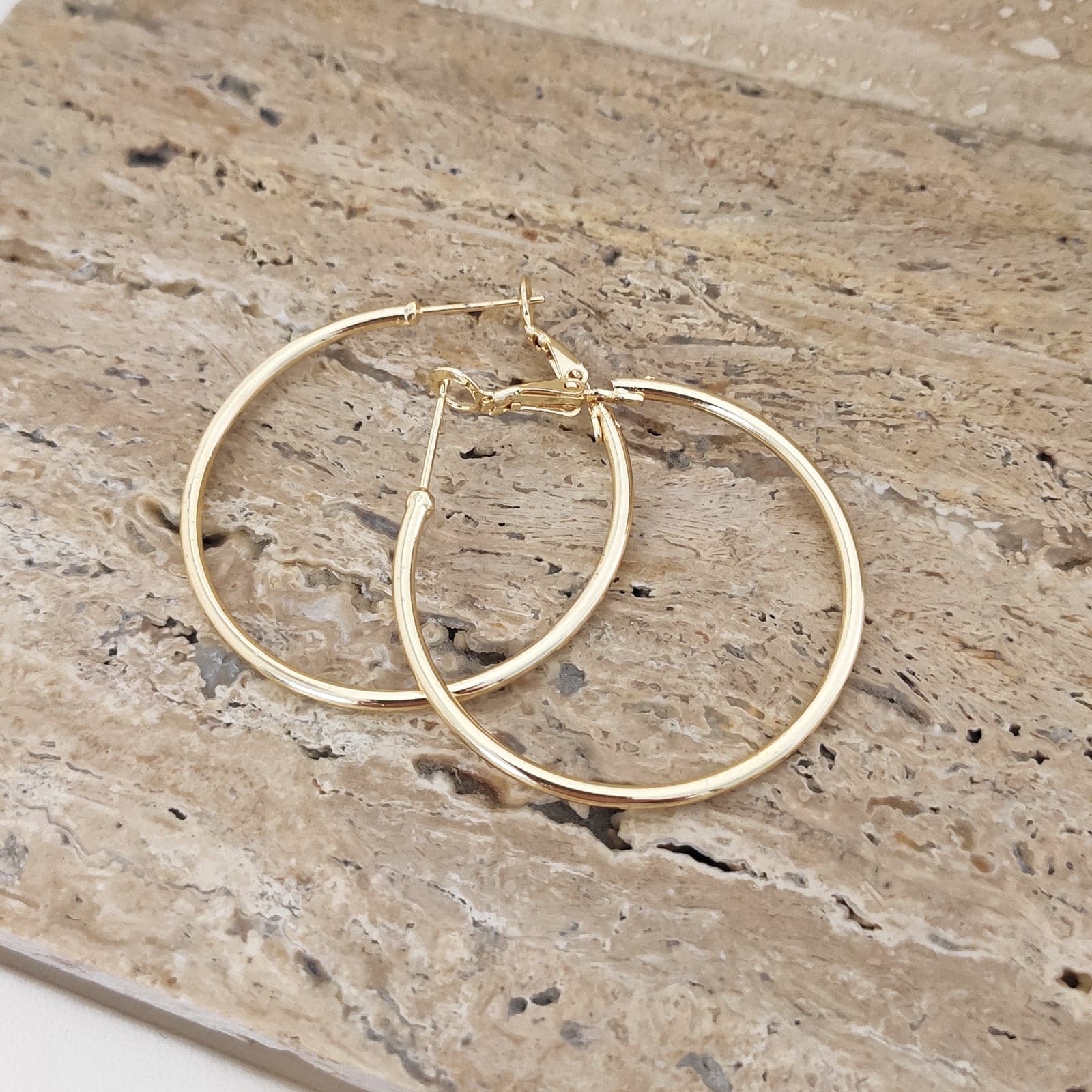 Gold tone hoop earrings on brass